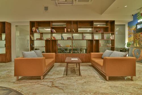a living room with two couches and a table at The Avatar Hotel & Convention in Mangalore