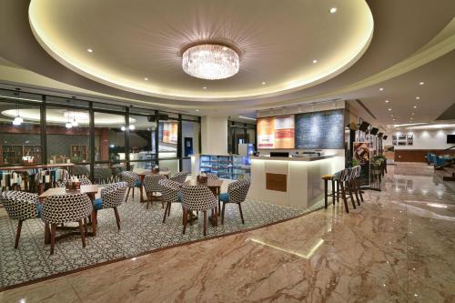a restaurant with tables and chairs in a building at The Avatar Hotel & Convention in Mangalore