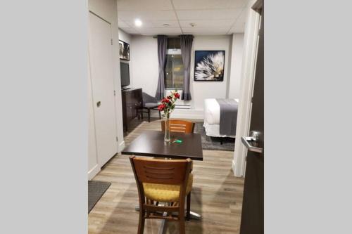 a living room with a table and a bedroom at Cozy Sweet Studio #6, 10 min to D.T. Ottawa in Gatineau