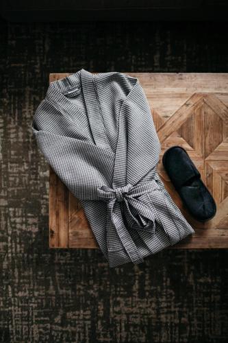 a robe and a pair of shoes on a wooden tray at Lapland Hotels Sky Ounasvaara in Rovaniemi
