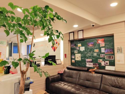 a living room with a leather couch and a chalkboard at Dongseongro ZERO guesthouse in Daegu