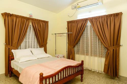 a bedroom with a bed with brown curtains and a bed sidx sidx sidx at Belljem Homes -your own private resort -6 BHK S in Trichūr
