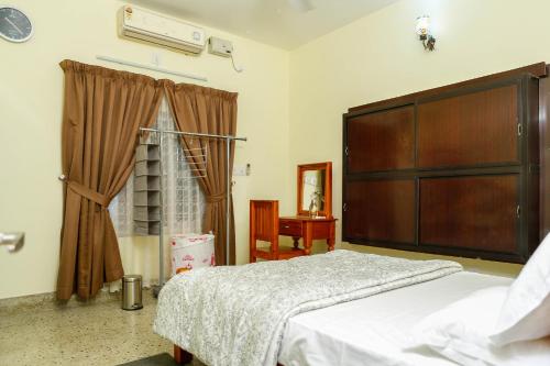 a bedroom with a large bed and a window at Belljem Homes -your own private resort -6 BHK S in Trichūr