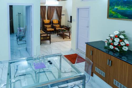 a living room with a glass table and a kitchen at Belljem Homes -your own private resort -6 BHK S in Trichūr