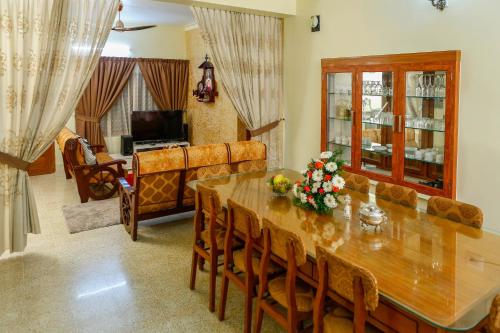 a dining room with a table and a couch at Belljem Homes -your own private resort -6 BHK S in Trichūr