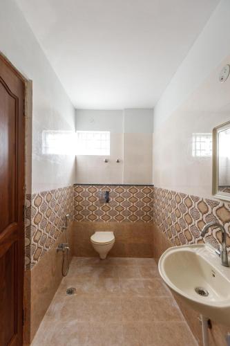 a bathroom with a toilet and a sink at Mistyblue Stays in Bengaluru