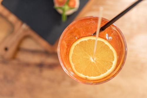 a glass of orange juice with a slice of orange at HEIMAT living like a local in Silandro