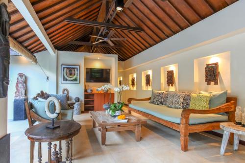 a living room with a bed and a table at Asrina Villa's Seminyak in Seminyak