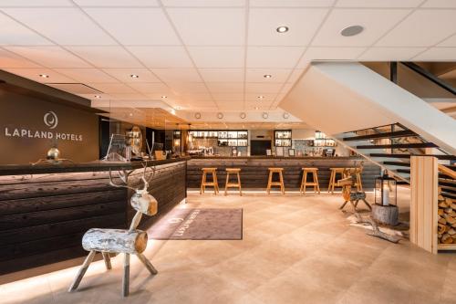 a restaurant with a bar and stools in a room at Lapland Hotels Sky Ounasvaara in Rovaniemi