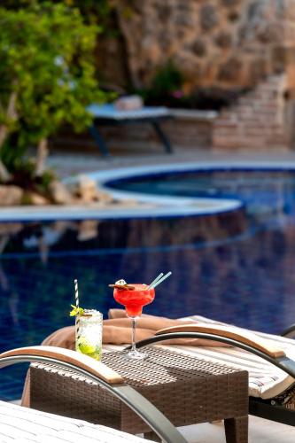 a drink sitting on a table next to a swimming pool at Dogan Hotel in Antalya