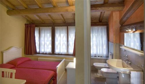 uma casa de banho com uma cama, um WC e um lavatório. em Villa Avesani em Pastrengo