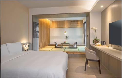 a bedroom with a bed and a table and chairs at Hotelday Sun Moon Lake in Yuchi