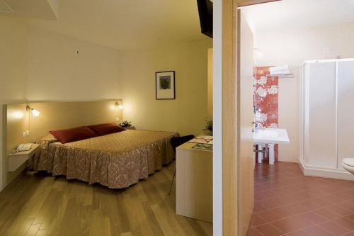niewielka sypialnia z łóżkiem i łazienką w obiekcie Hotel Granducato w mieście Montelupo Fiorentino
