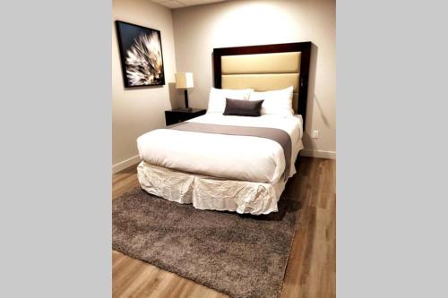 een slaapkamer met een groot bed en een tapijt bij Cozy Sweet Studio #5, Only 10 min to D.T. Ottawa in Gatineau