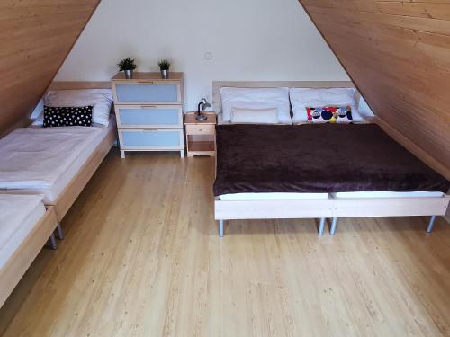 a bedroom with two beds and a wooden floor at Apartmány Dolní Moravice in Dolní Moravice