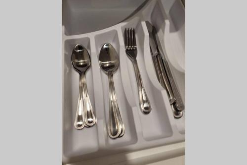 four silver utensils are sitting on a plate at Cozy Sweet Studio #4, Only 10 min to D.T. Ottawa in Gatineau