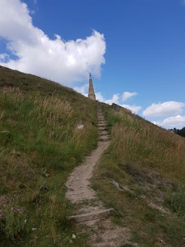 a dirt path leading up a hill with a church at Schupplerova vila in Hoštejn