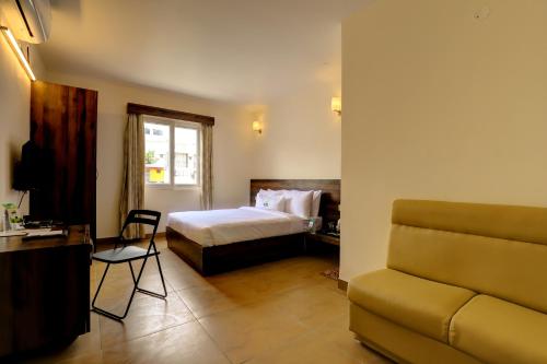 a hotel room with a bed and a couch at MySpace Express GD Inn in Bengaluru