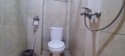 a bathroom with a toilet and a shower at Votel Hotel De'Pratnya Kediri in Kediri