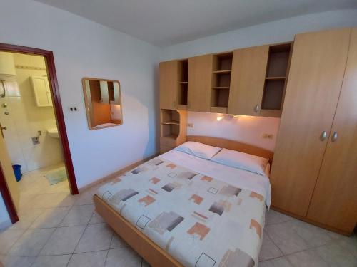 Apartments Elizabeta في Draga Bašćanska: غرفة نوم صغيرة مع سرير ومرآة