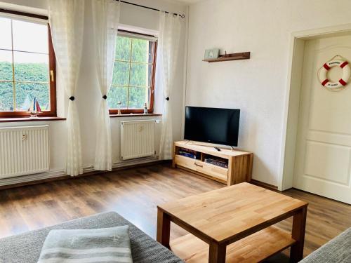 - un salon avec une télévision et une table basse dans l'établissement Ferienwohnung Heiligenhagen, à Satow