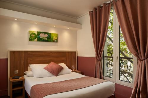 a bedroom with a bed and a large window at Grand Hotel Nouvel Opera in Paris