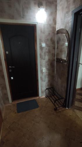 La salle de bains est pourvue d'une porte noire et d'un miroir. dans l'établissement 1-ная квартира по адресу Глушко 28, à Odessa