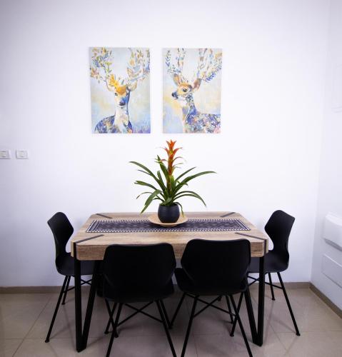 a dining room table with chairs and a plant on it at הפינה בנחל in Hagoshrim