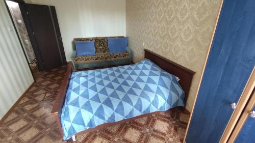 a small bedroom with a blue bed and blue pillows at 1-ная квартира по адресу Глушко 28 in Odesa