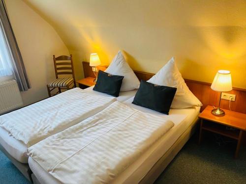 a bedroom with a large white bed with two pillows at Hotel Alte Mühle in Elsfleth