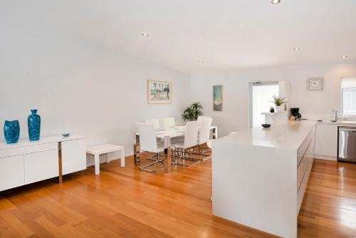 a kitchen and dining room with white cabinets and a table at Fairview - Margaret River in Margaret River Town