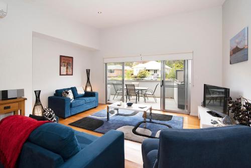 a living room with a blue couch and a table at Fairview - Margaret River in Margaret River Town
