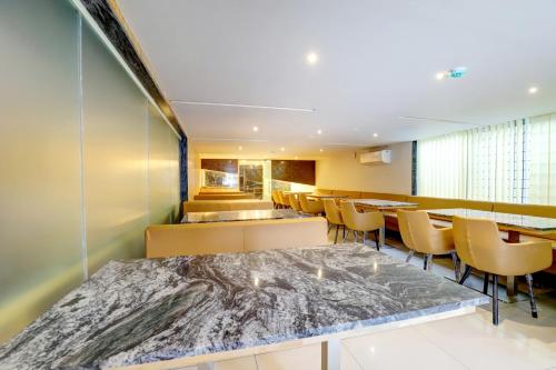 a restaurant with a large marble table and chairs at MySpace Express GD Inn in Bengaluru