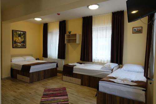 a hotel room with two beds and a rug at Борник Хил / Bornik Hill in Devin