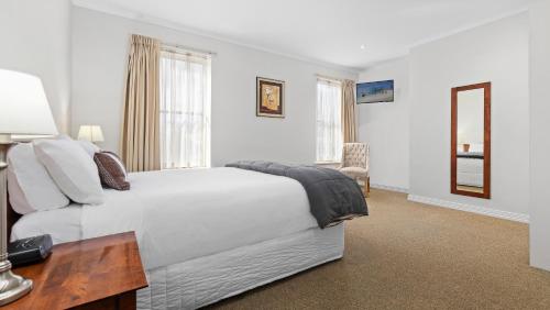 um quarto com uma cama, uma mesa e um espelho em Lake Inn - Ballarat em Ballarat