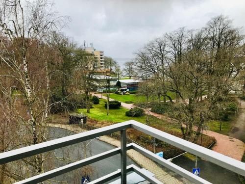 a balcony with a view of a park with trees at Ferienwohnung Skowronek am Kurpark in Glücksburg