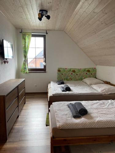 a bedroom with two beds and a dresser and a window at Vila Snezienka in Stará Lesná