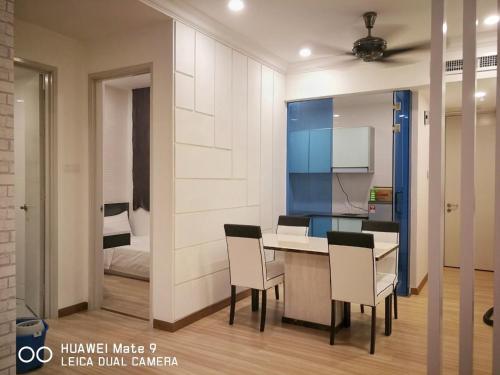 a kitchen with a table and chairs and a bedroom at ExcluSuites Malacca @ The Wave Residence in Melaka