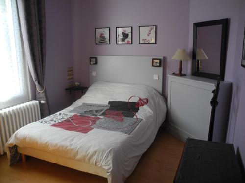 - une chambre avec un lit et une robe dans l'établissement Les Vergnes Mancelles, au Mans