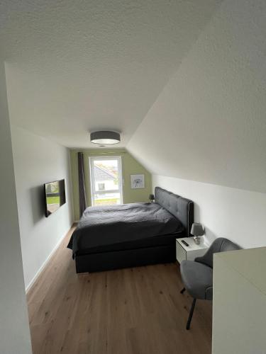 a small bedroom with a bed and a window at Wangerbrise in Wangerland