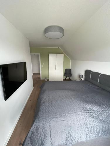 a bedroom with a bed and a flat screen tv at Wangerbrise in Wangerland