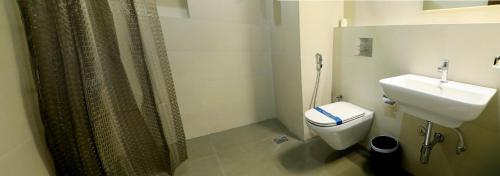 a bathroom with a shower and a toilet and a sink at GG HOTELS in Tiruppūr