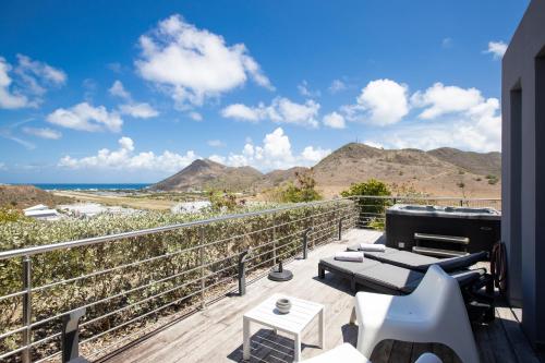 a balcony with a view of the ocean and mountains at The Rock in Cul de Sac