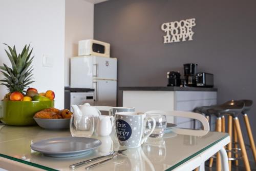 a kitchen with a table with plates and mugs on it at The Rock in Cul de Sac