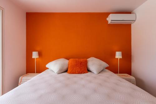 a bedroom with a bed with an orange wall at The Rock in Cul de Sac