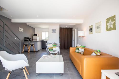 a living room with a orange couch and white chairs at The Rock in Cul de Sac