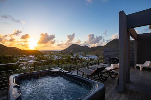 a hot tub on the deck of a house with the sunset at The Rock in Cul de Sac