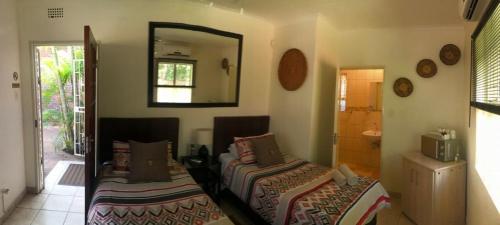a bedroom with two beds and a mirror at Danamara Garden Studios in Phalaborwa