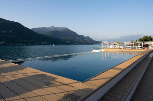 a swimming pool on the side of a lake at Ah Porticcioli Boutique Apartments in San Felice del Benaco