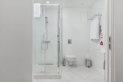 a bathroom with a glass shower and a toilet at 1 ART HOTEL in Moscow